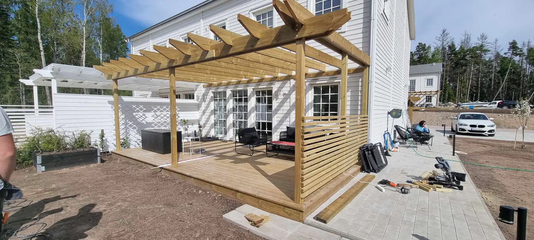 Puidust terrass ja pergola eramaja kõrval